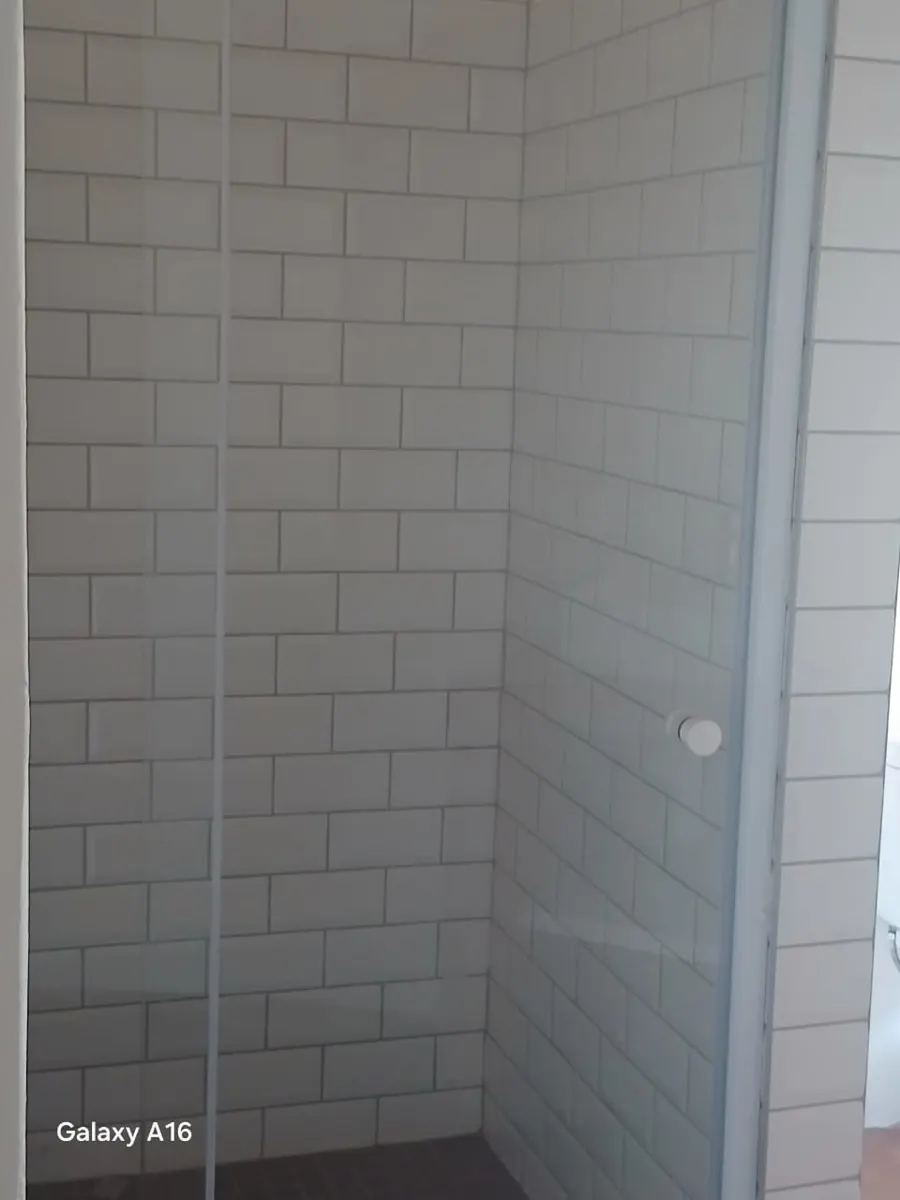Subway tiled walk-in shower with glass door