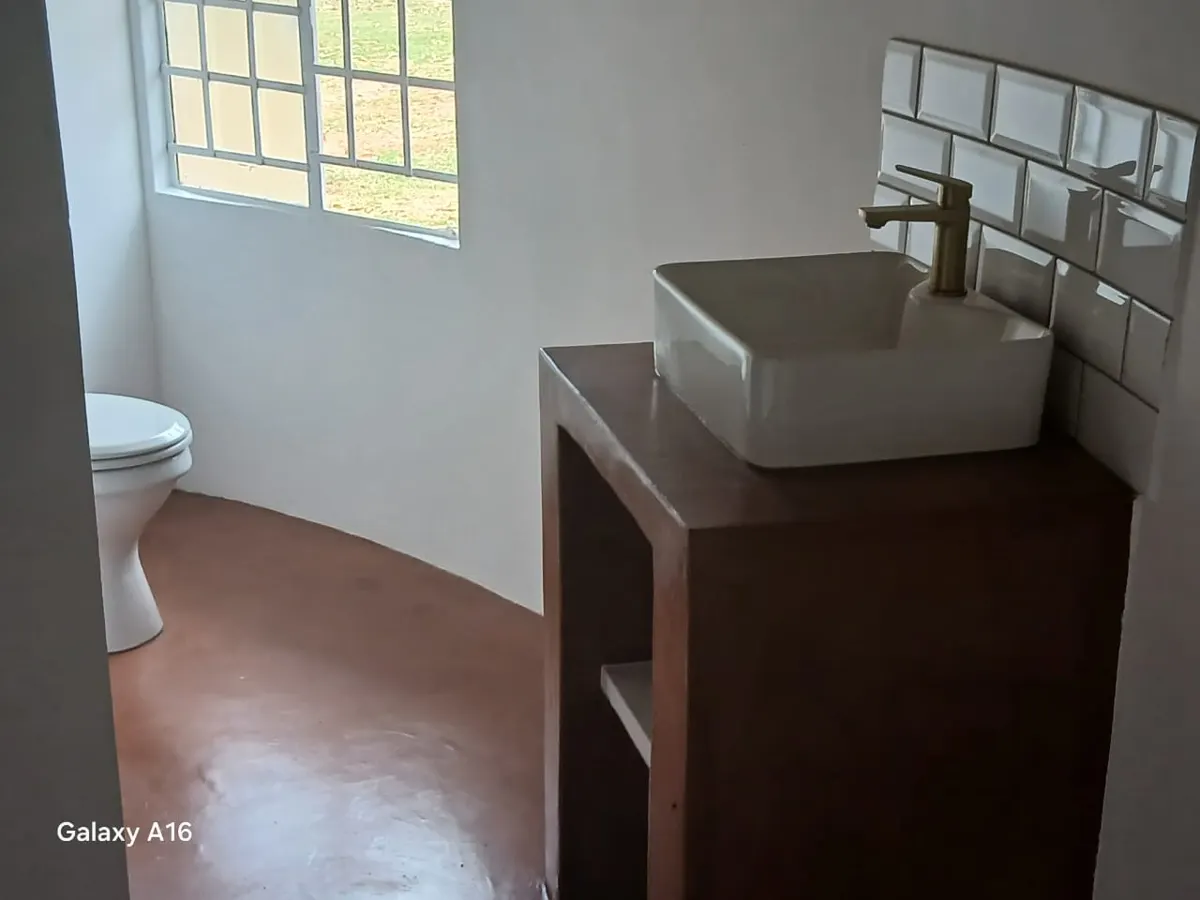 Bathroom with vessel basin, gold mixer and screed floor
