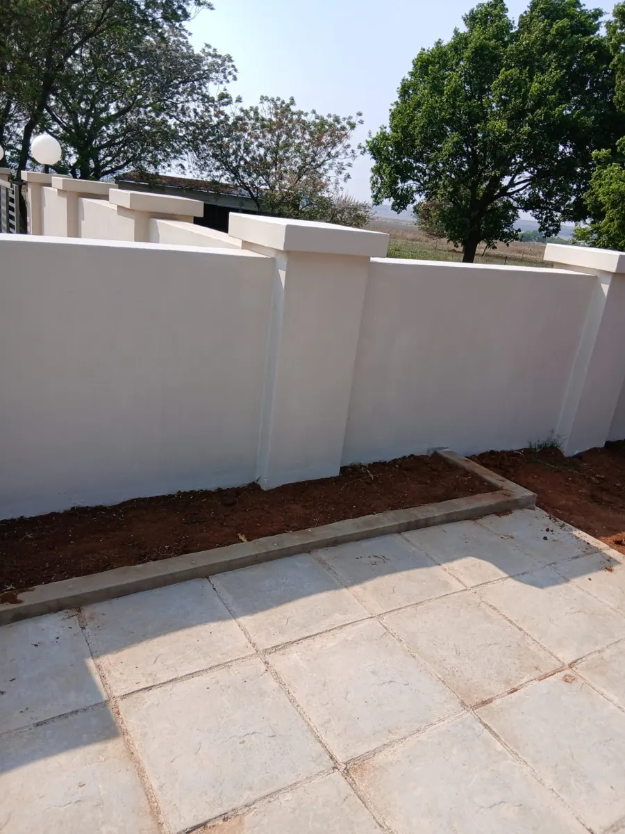 New plastered boundary wall with pillars and paving